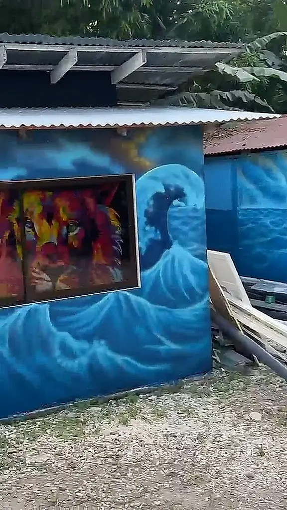 Mural de un león de colores sobre una ola