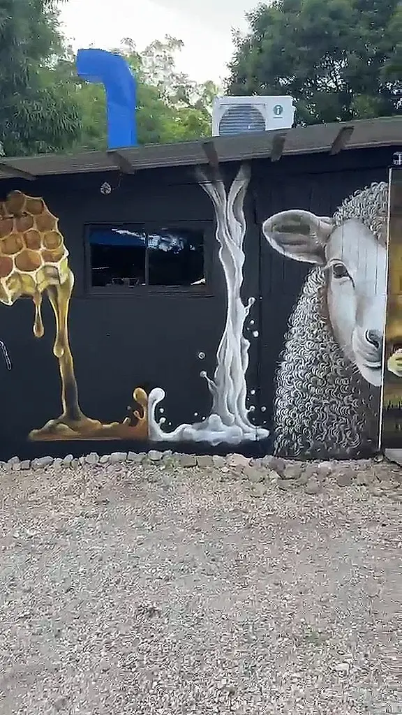 Mural de miel y leche cayendo junto a un cordero